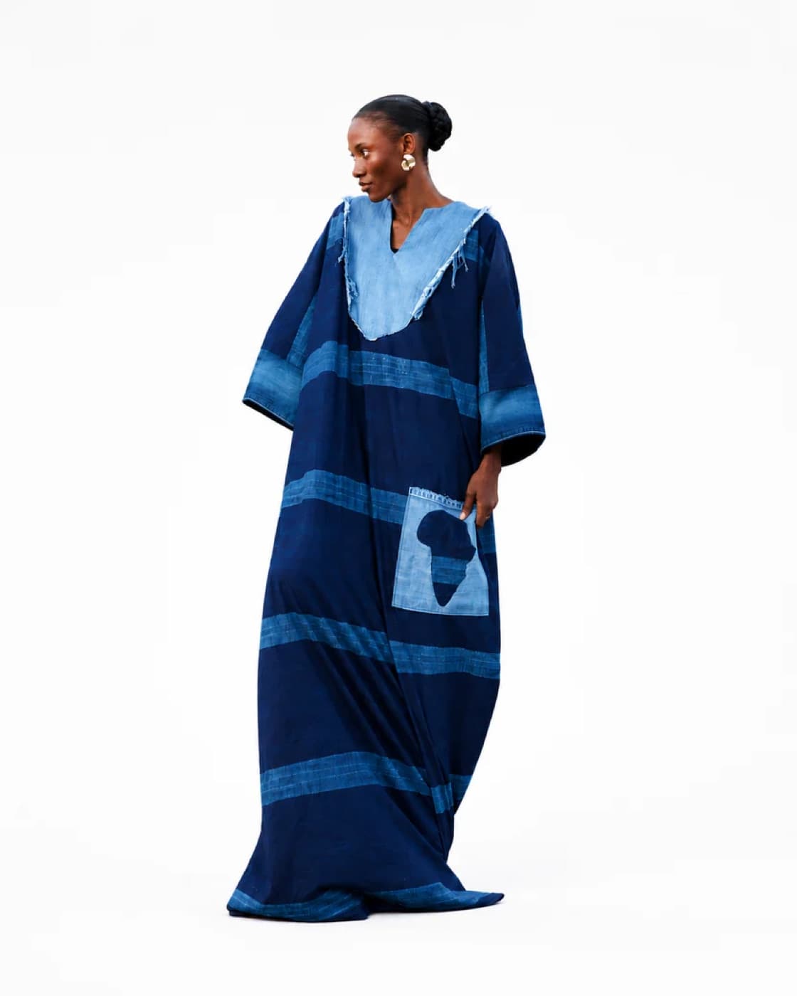 Model wearing a floor-length indigo adire bùbá with wide sleeves