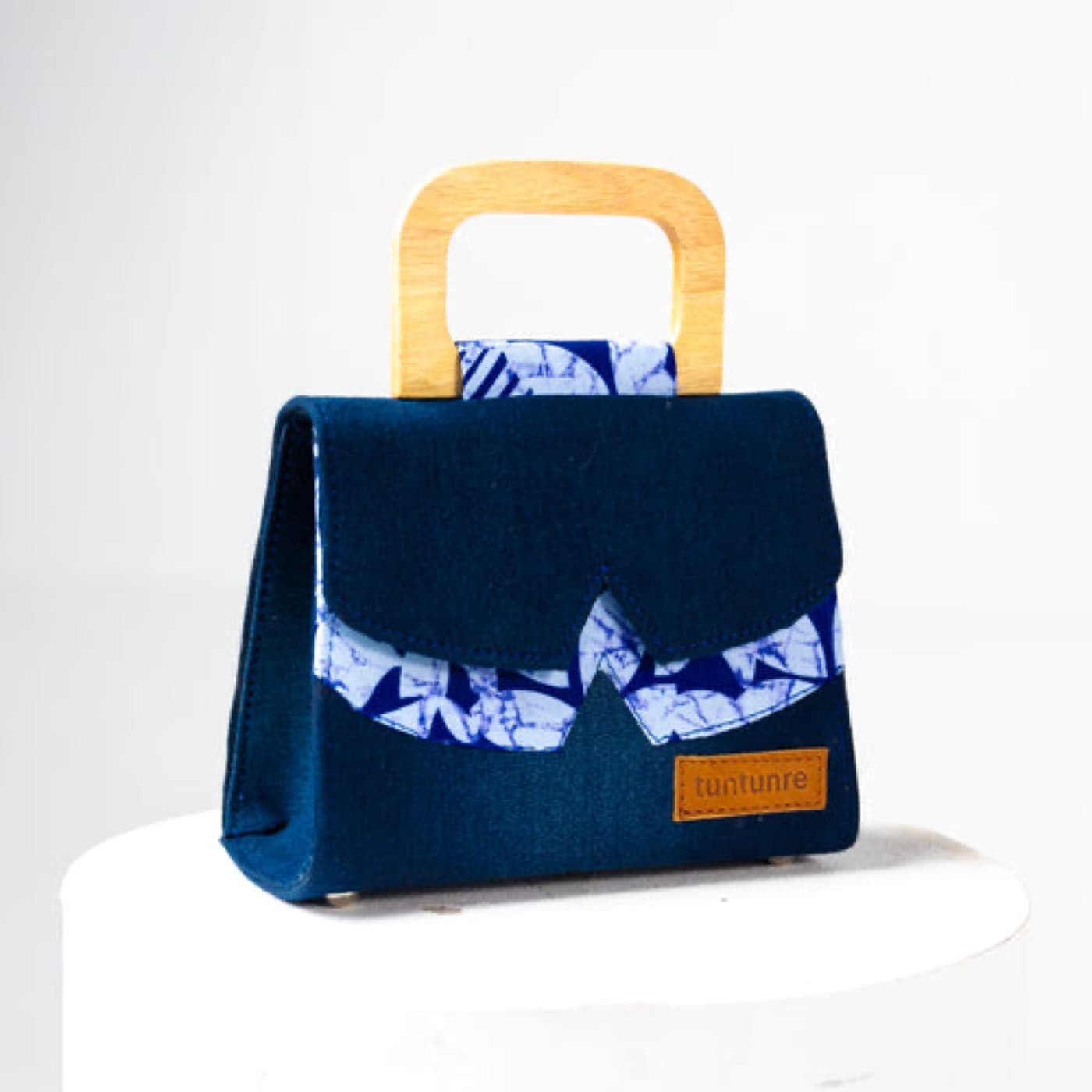Navy denim mini bag with an adire-print panel and a wooden top handle
